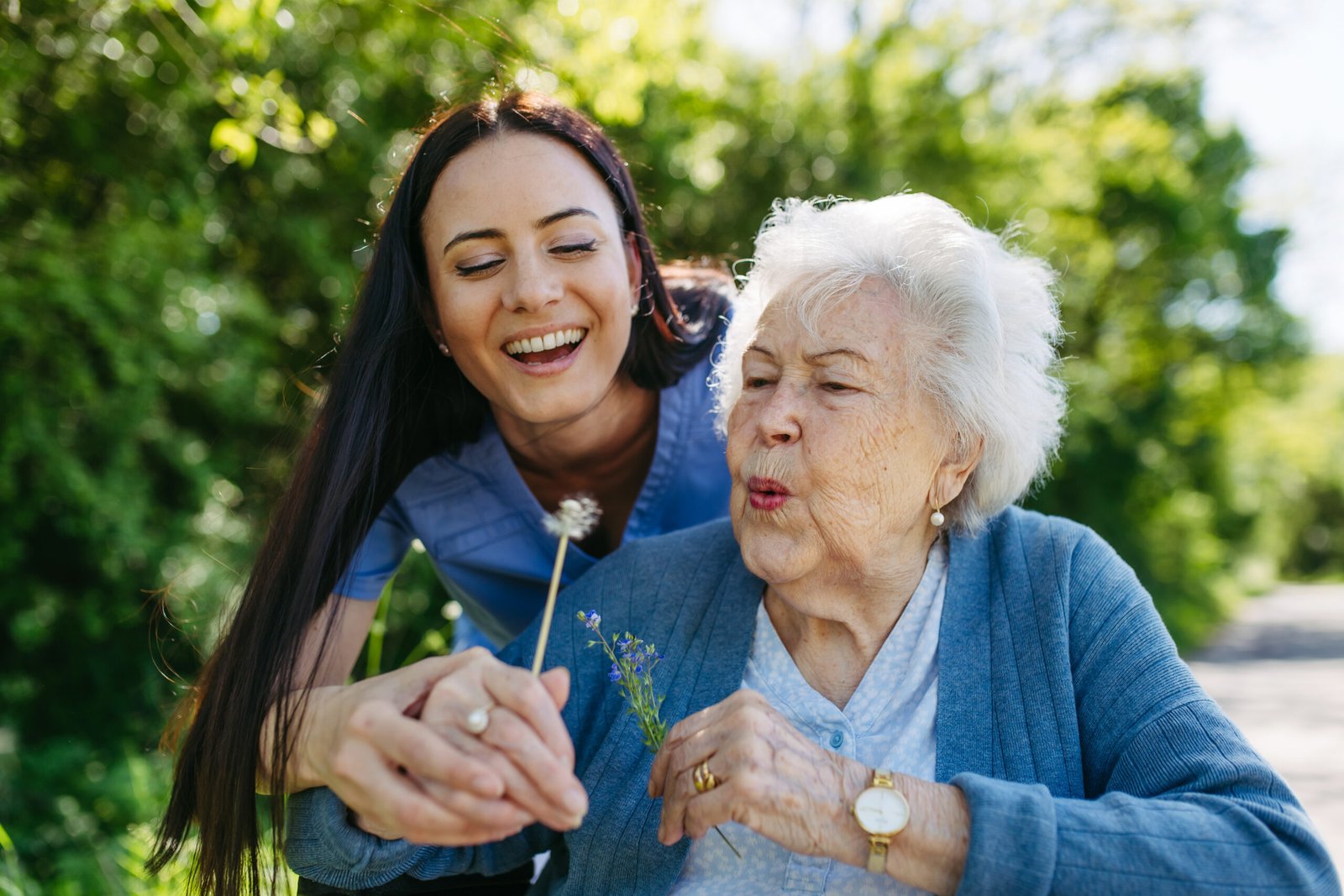 Caregiver reviewing a care plan together with a senior resident and her daughter at the kitchen table